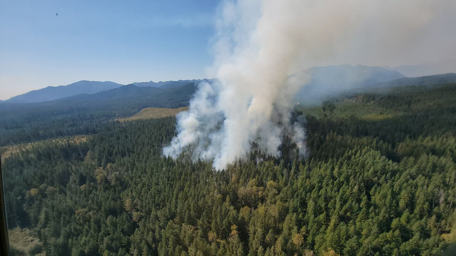 Smoke is visible rising from a fire in the Olympic National Forest that was first reported Wednesday.